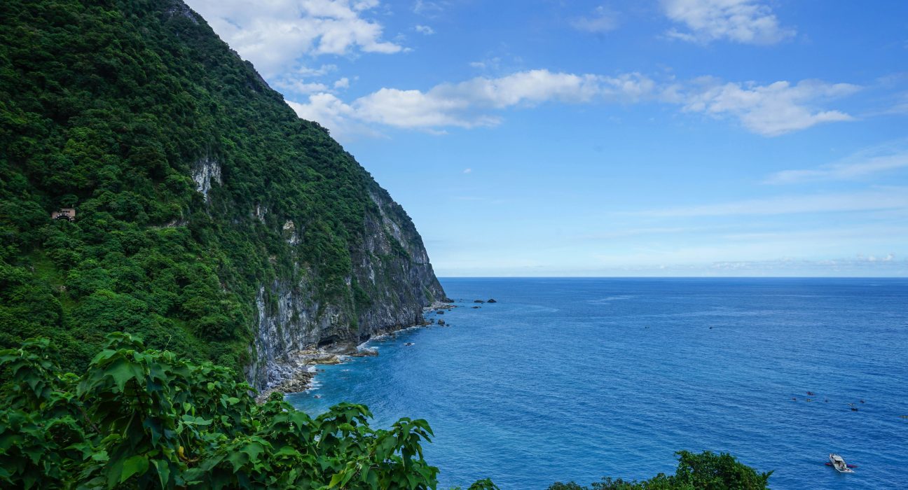 Scenic view of Hualien coastline with the Pacific Ocean meeting lush green mountains.