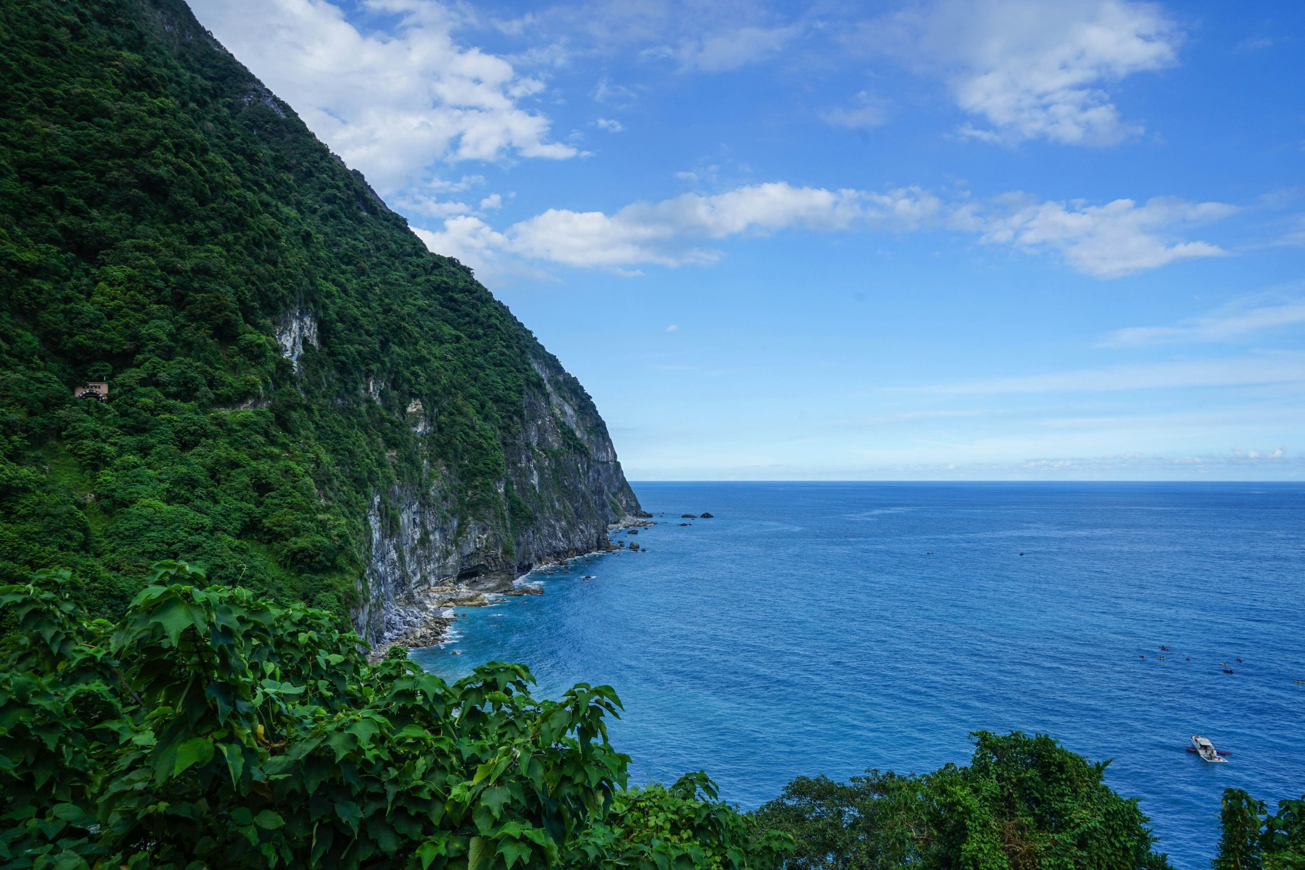 Scenic view of Hualien coastline with the Pacific Ocean meeting lush green mountains.